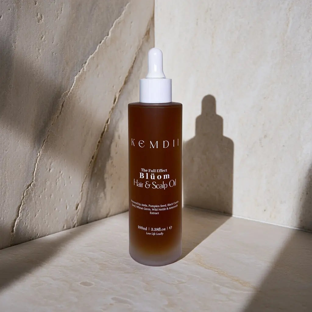 KEMDII Blüom botanical scalp oil with rosemary and nettle, photographed on a marble background with soft shadows
