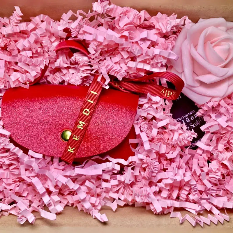 KEMDII Blüom Hair & Scalp Oil shown in luxury gift packaging with pink filler and red faux leather pouch